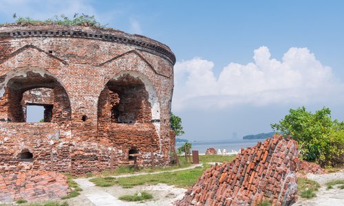 ruin of round redbrick building with arches - a martello tower