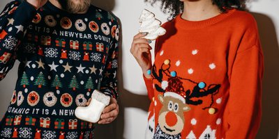 Man and a woman wearing Christmas jumpers