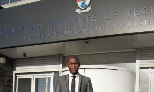 man standing in front of a college building