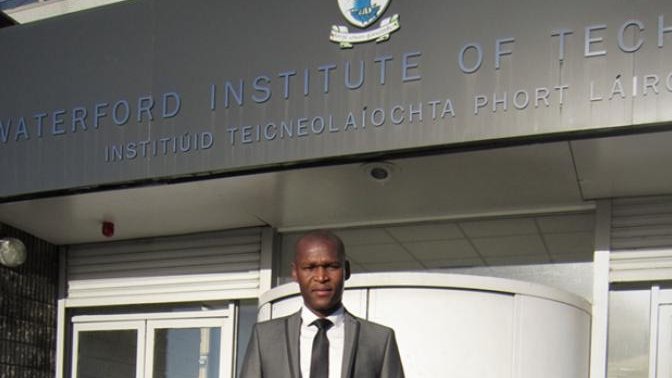 man standing in front of a college building