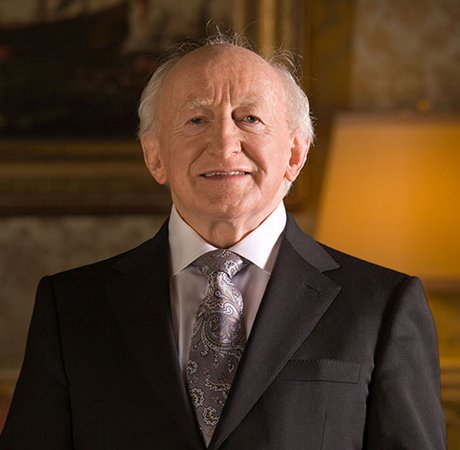 man in suit smiling at camera with lamp in the background