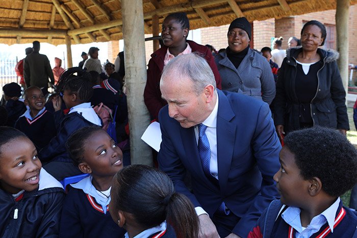 man talking to school kids in uniform