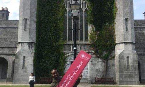 man holding an NUIG sign