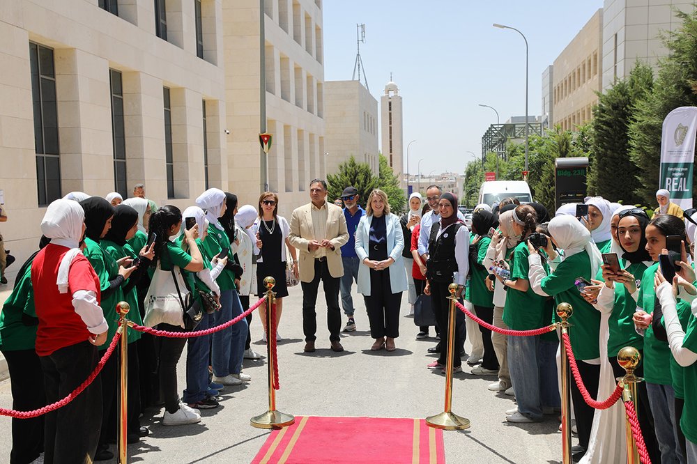 Ambassador Bolger and JoYS chairperson walking down a red carpet surrounded by students
