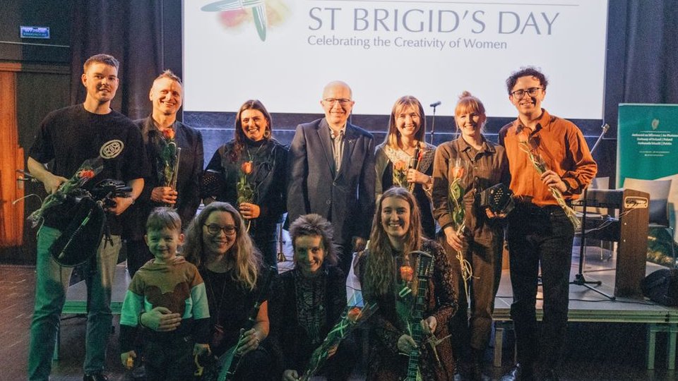 A collection of musicians in two rows posing for a photo