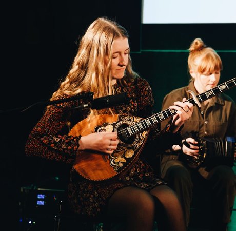 Two musicians playing instruments on stage