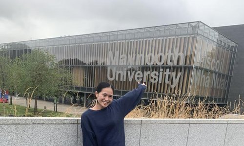 woman in front of Maynooth University sign