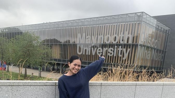 woman in front of Maynooth University sign